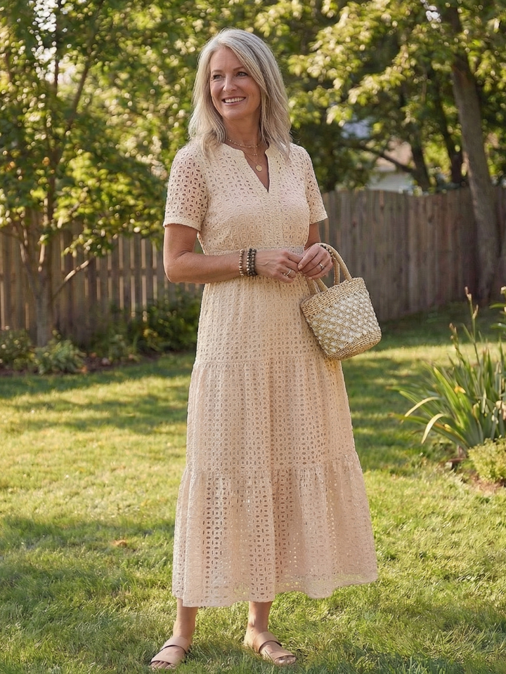 Side view of a women's eyelet tiered midi dress, showcasing its flowy tiered skirt and relaxed short sleeve fit.