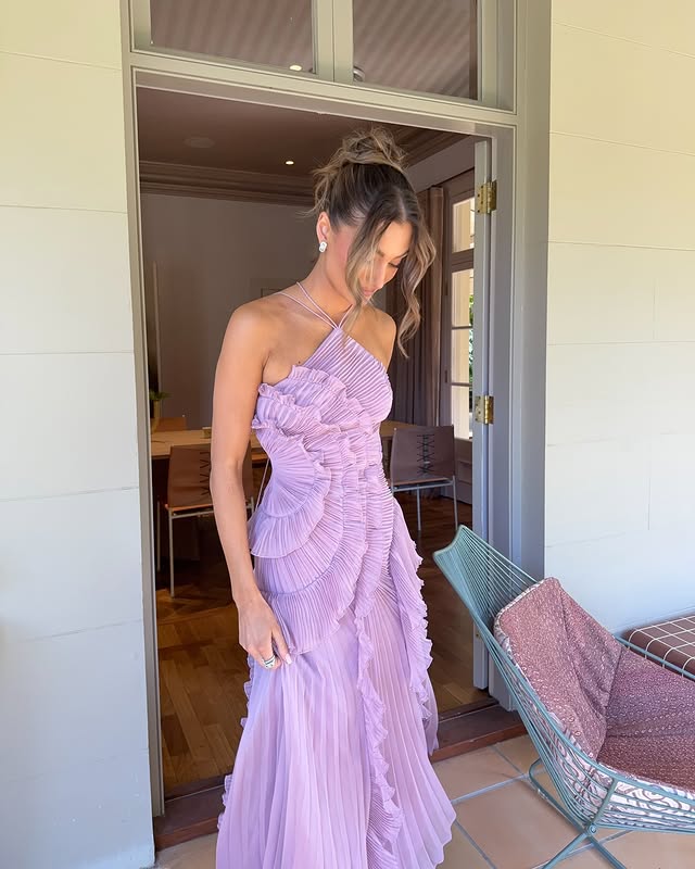 Model wearing a beautiful white ruffled halter maxi dress, perfect as a formal party gown.
