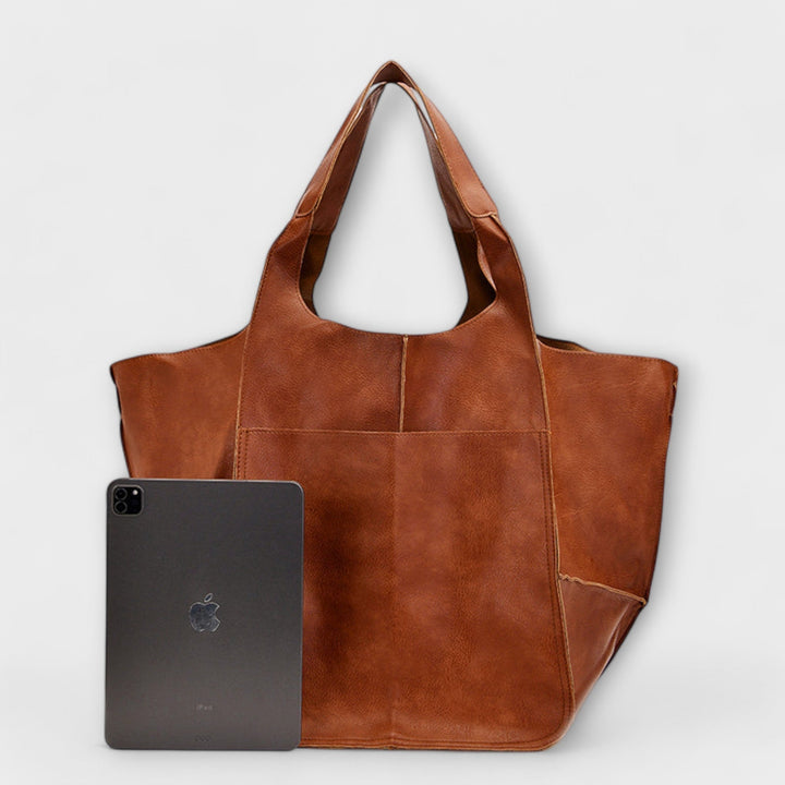 Elegant black leather travel bag for women, an oversized duffel style, carry-on friendly.