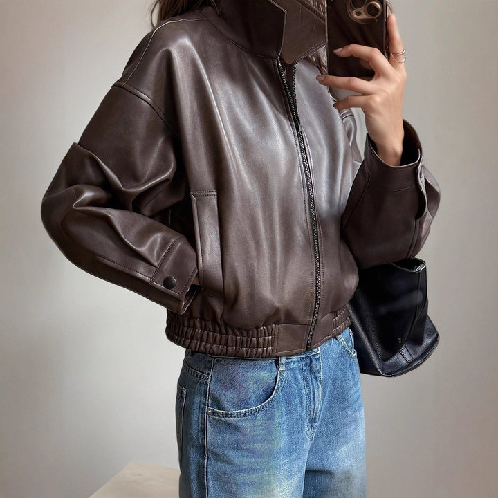 Women's modern black leather zip-up bomber jacket, versatile for casual or smart-casual fall fashion.