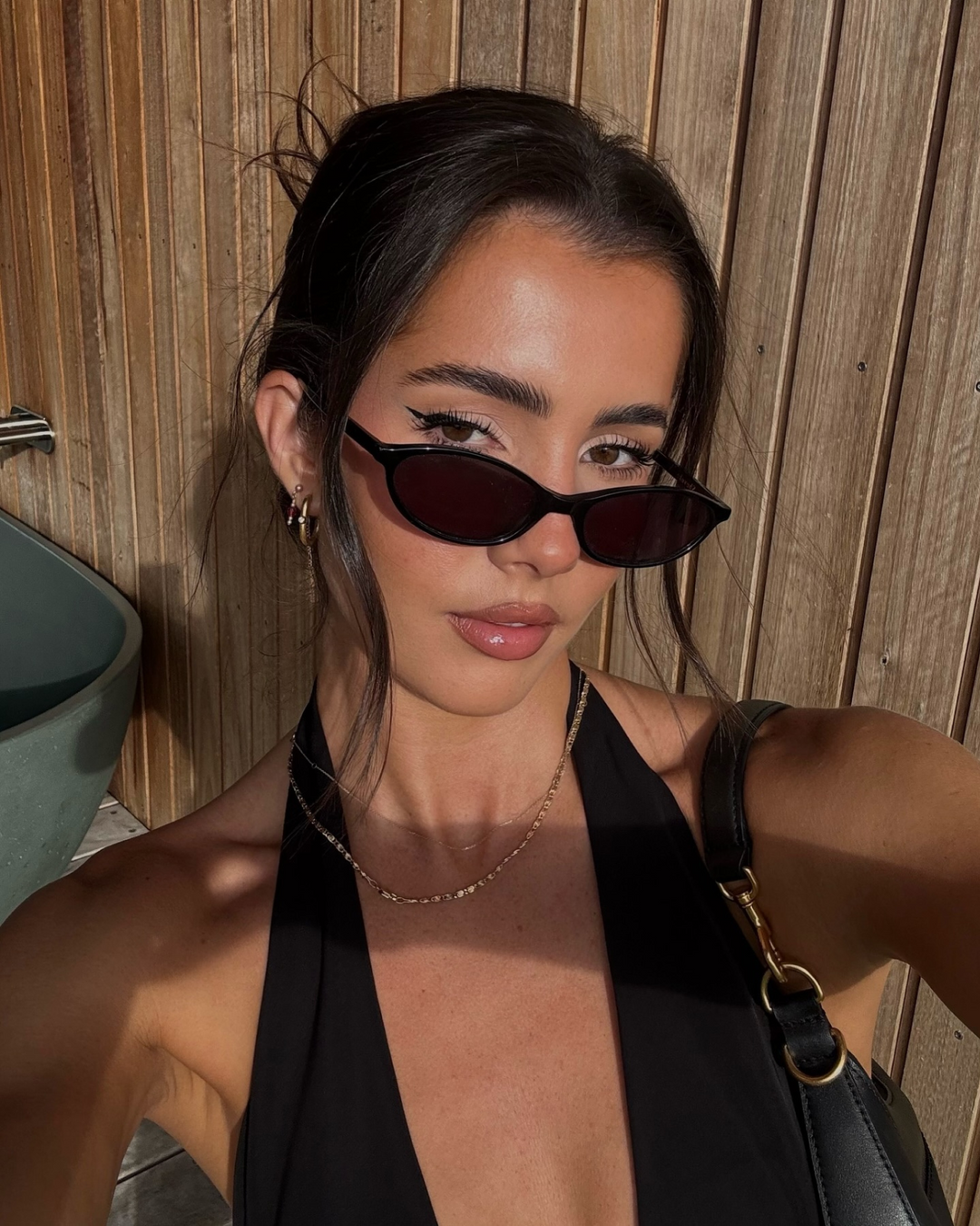 Contemporary women's oval sunglasses in black, blending 90s retro aesthetics with a chic minimalist design.
