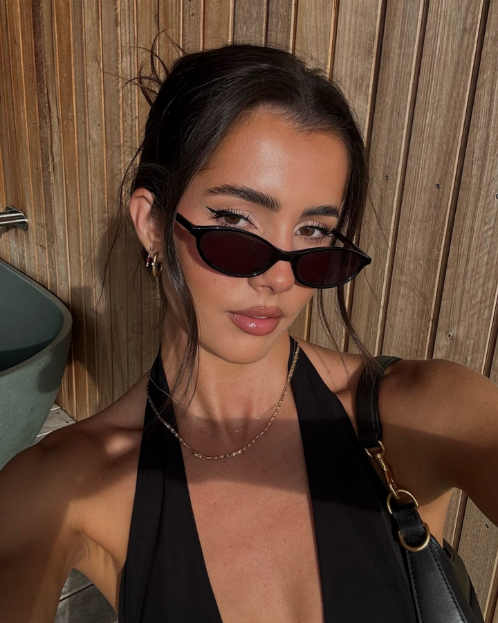 Contemporary women's oval sunglasses in black, blending 90s retro aesthetics with a chic minimalist design.