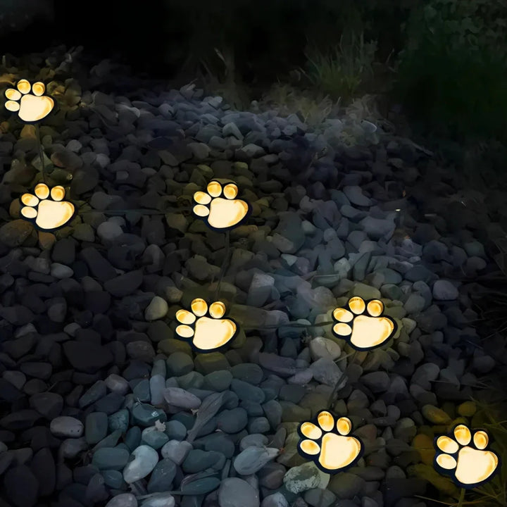 Multicolor paw print solar path lights, waterproof LED outdoor lighting for whimsical garden decor.