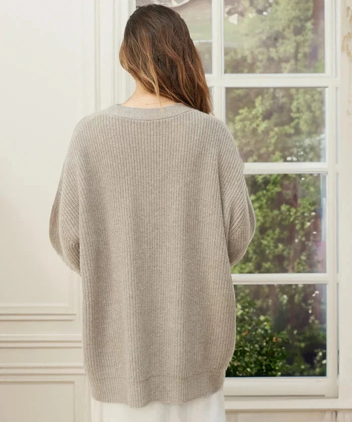 Detail of the button-front closure on a women's elegant knit cardigan vest.