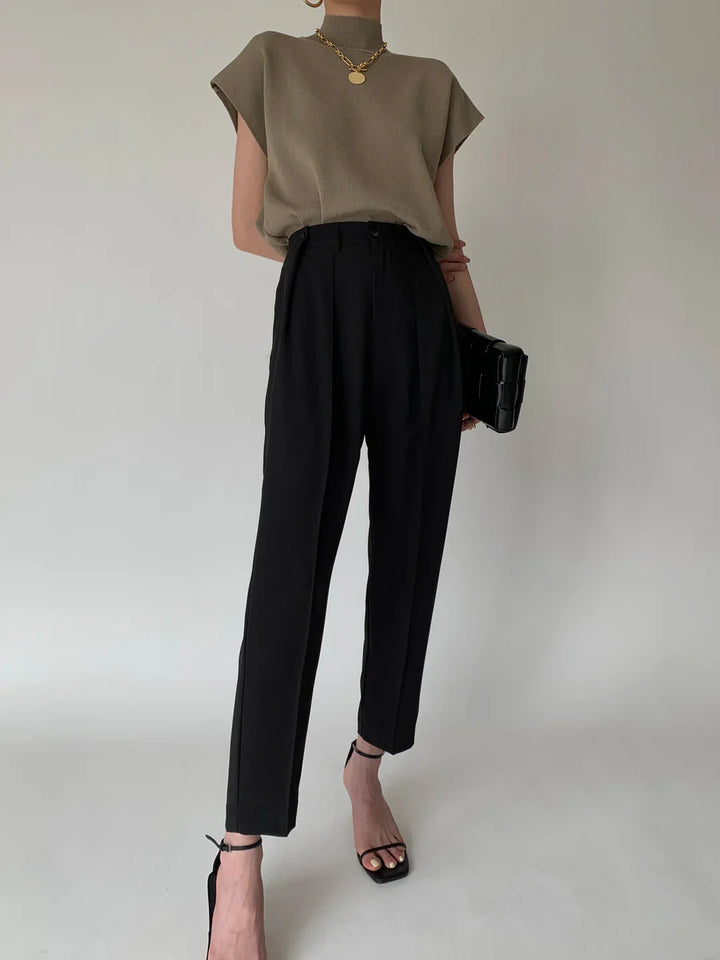 Chic women's sleeveless top, mock neck design, prominent padded shoulders. Office to evening.