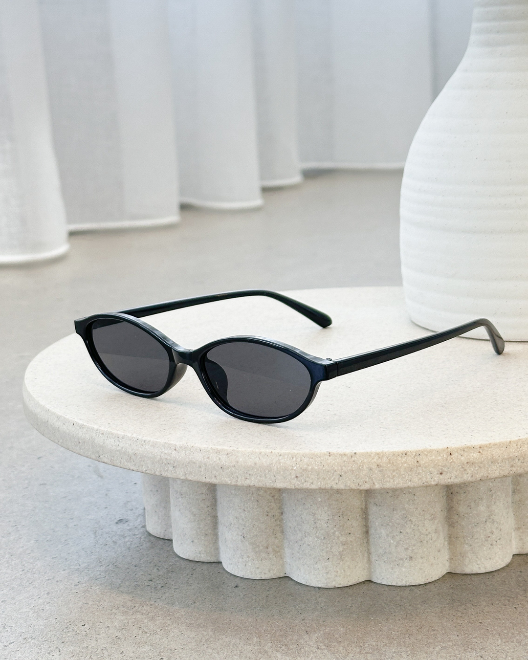 Retro 90s oval sunglasses for women, a sleek accessory featuring a minimalist frame for a modern look.