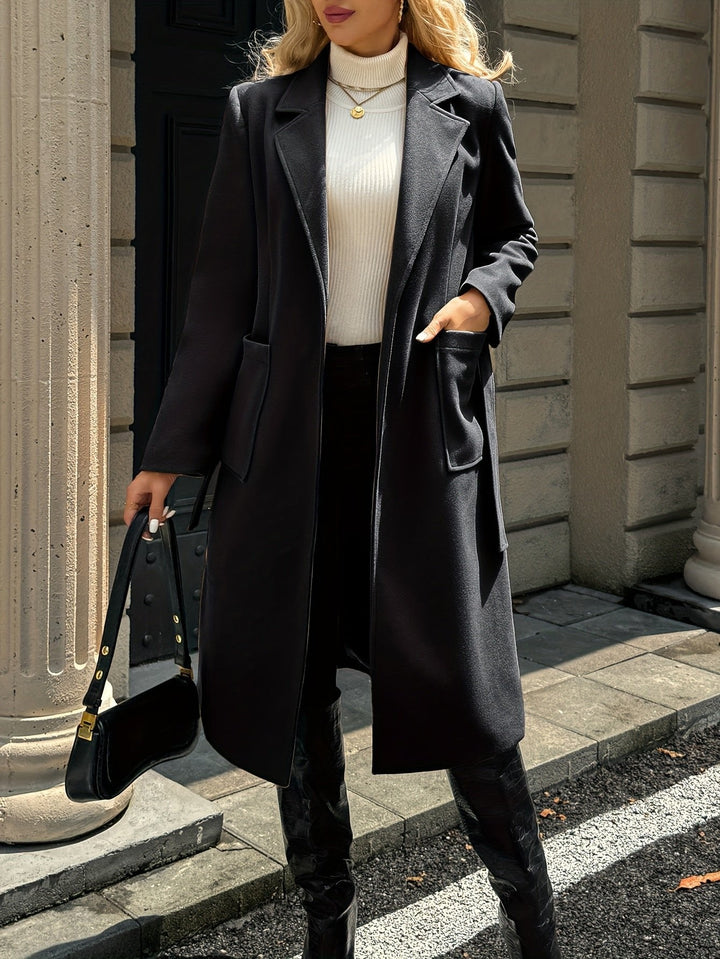Woman sitting elegantly in a sophisticated belted trench coat. Versatile office wear and formal coat.