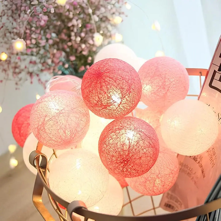 Cotton ball string lights draped over a bed, creating a dreamy and cozy bedroom escape.