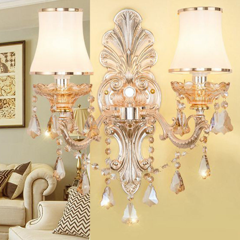 Beautiful gold Victorian wall lamp casting warm ambient light, adorned with a decorative shade & crystals.