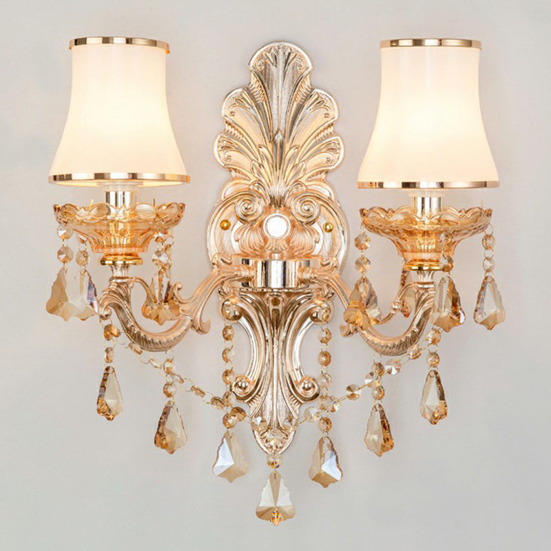 Side view of an elegant Victorian sconce with a fabric shade, crystal drops, and antique-style gold metalwork.