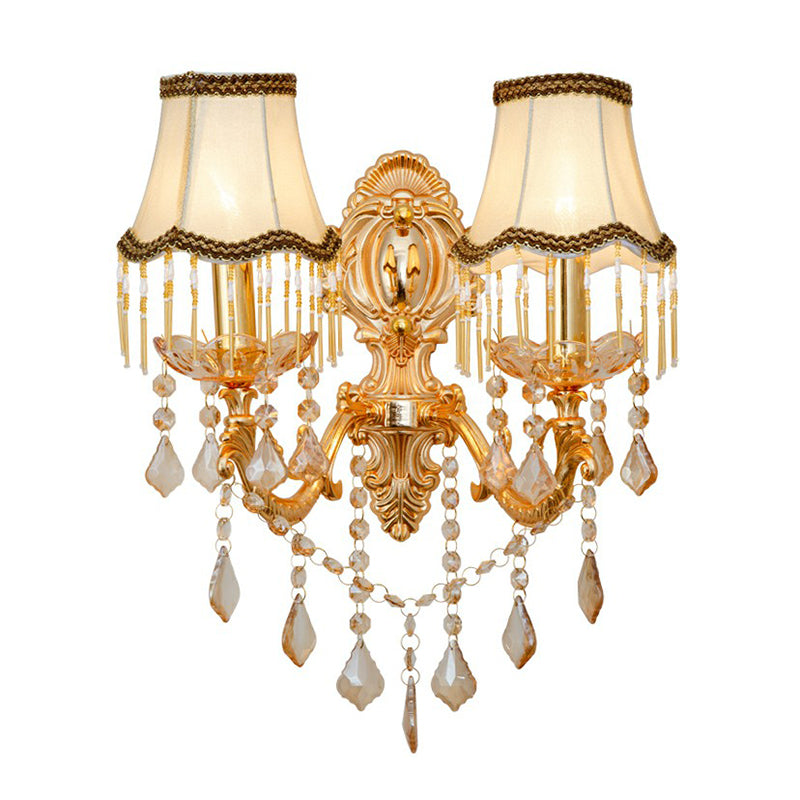 Silver Victorian sconce featuring intricate metalwork, a delicate shade, & sparkling crystal accents. Ambient light.