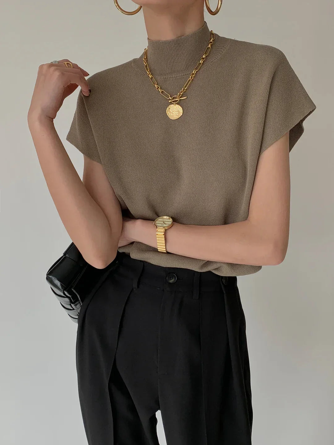Versatile women's top: Mock neck, sleeveless, with sharp padded shoulders. Smart and chic.