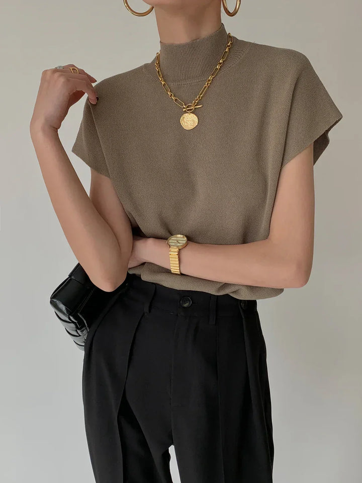 Versatile women's top: Mock neck, sleeveless, with sharp padded shoulders. Smart and chic.