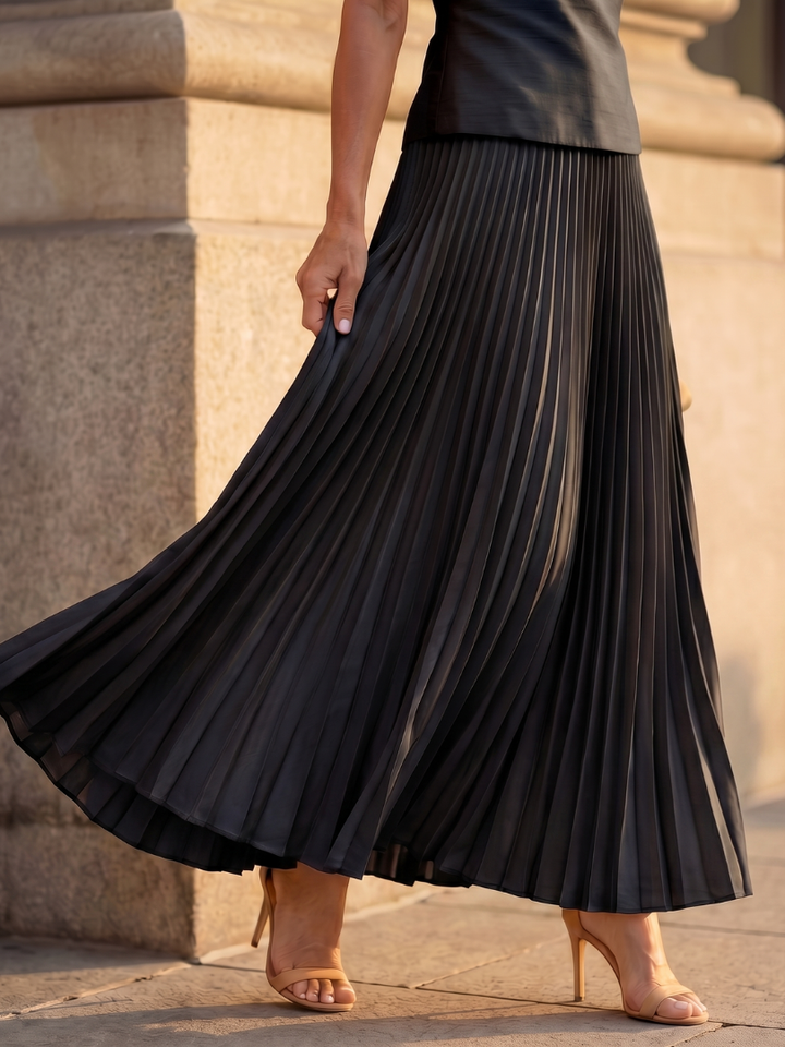 Women's two-piece set featuring a flowing pleated maxi skirt and a chic structured bodice top.