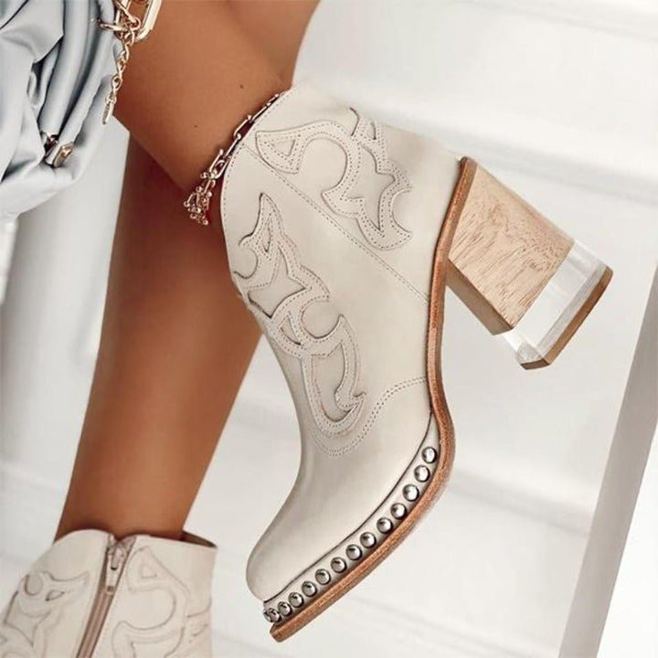 Western-style women's cowboy booties featuring modern cut-outs & a durable block heel. Trendy footwear.