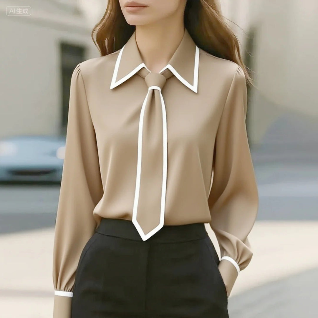 Chic women's tie-neck blouse with striking contrast details. Versatile long sleeve top for work or sophisticated casual.
