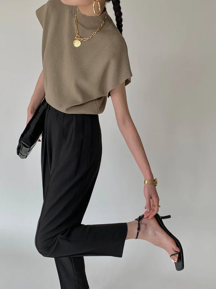 Elegant women's mock neck top, sleeveless, with sophisticated padded shoulder detail.