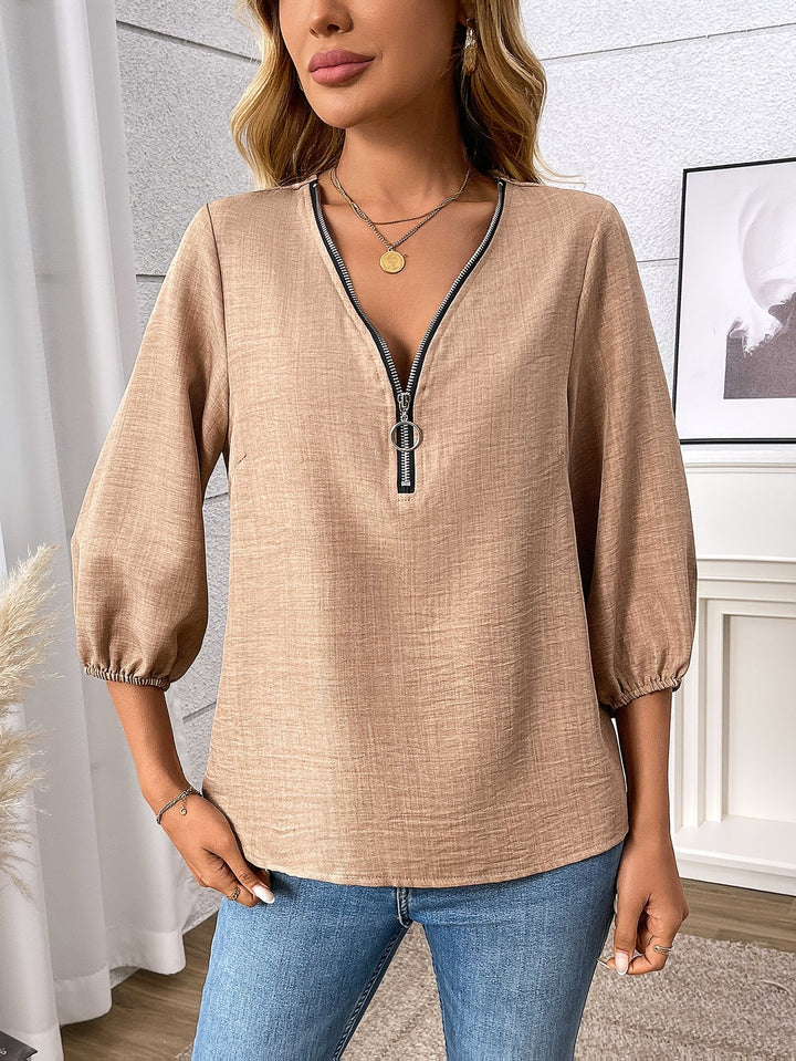 Fashionable women's blouse: zip-front V-neck, 3/4 sleeves. Easy-to-wear elegant top for work or stylish outings.