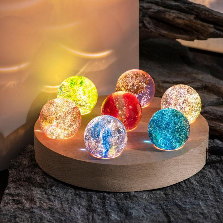 Modern crystal galaxy orb lamp with a radiant wooden LED base, providing soft ambient lighting.