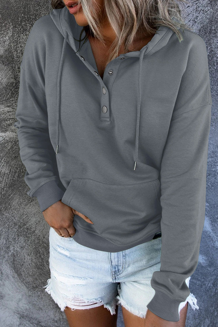 Woman posing in a comfy hooded sweater, showcasing everyday casual style.