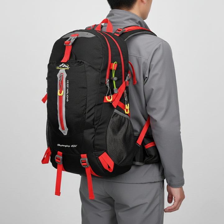 Unisex traveler wearing a 40L water resistant hiking backpack on an adventurous outdoor trail, carrying essential gear.