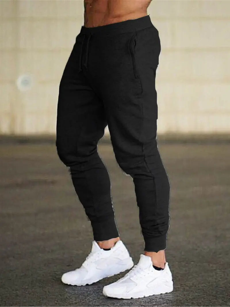 Black men's relaxed fit joggers, ideal for athletic activities or comfortable lounging, featuring an elastic waist.