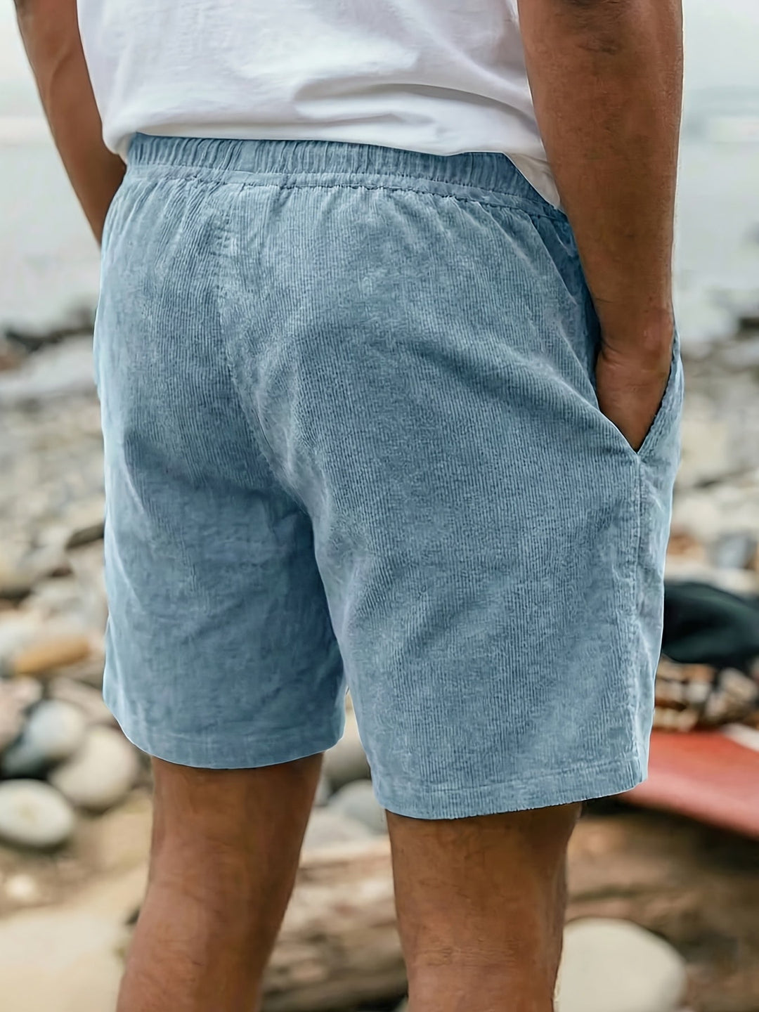 Man wearing relaxed fit dark green drawstring shorts, showcasing easy summer style.