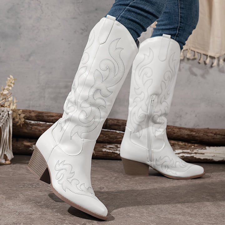 White women's cowboy boots, knee high with intricate western patterns, ideal for a stylish statement.