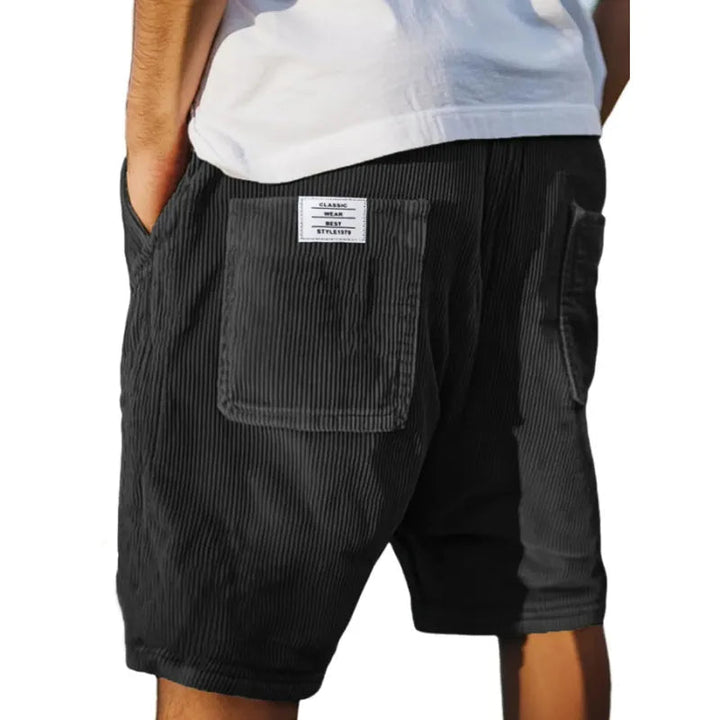 Man modeling smart textured tailored shorts with a shirt, showcasing polished men's summer fashion.