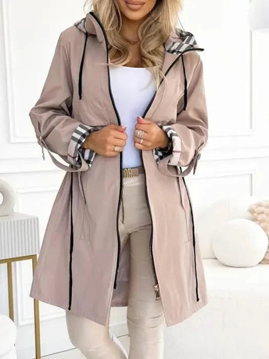 Tailored women's hooded waterproof jacket for commuting & travel, offering all-weather protection & style.