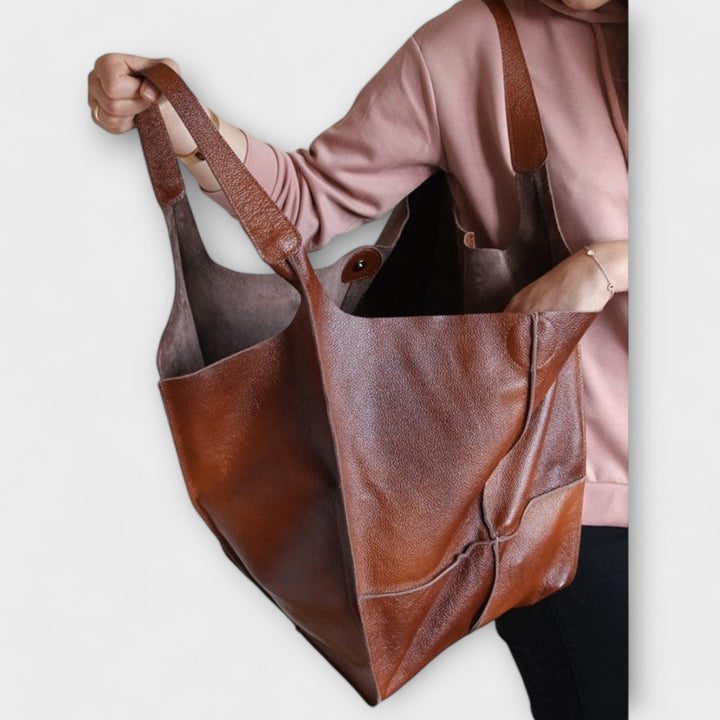 Inside view of large women's leather travel bag, showing spacious main compartment.