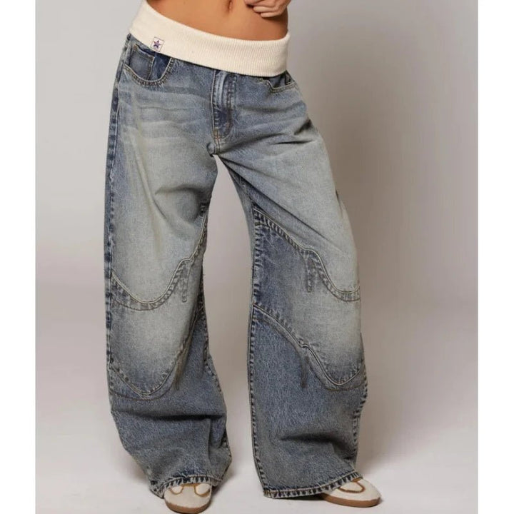 Close-up of women's vintage patchwork wide leg jeans. Features unique fabric blends and a light wash finish.