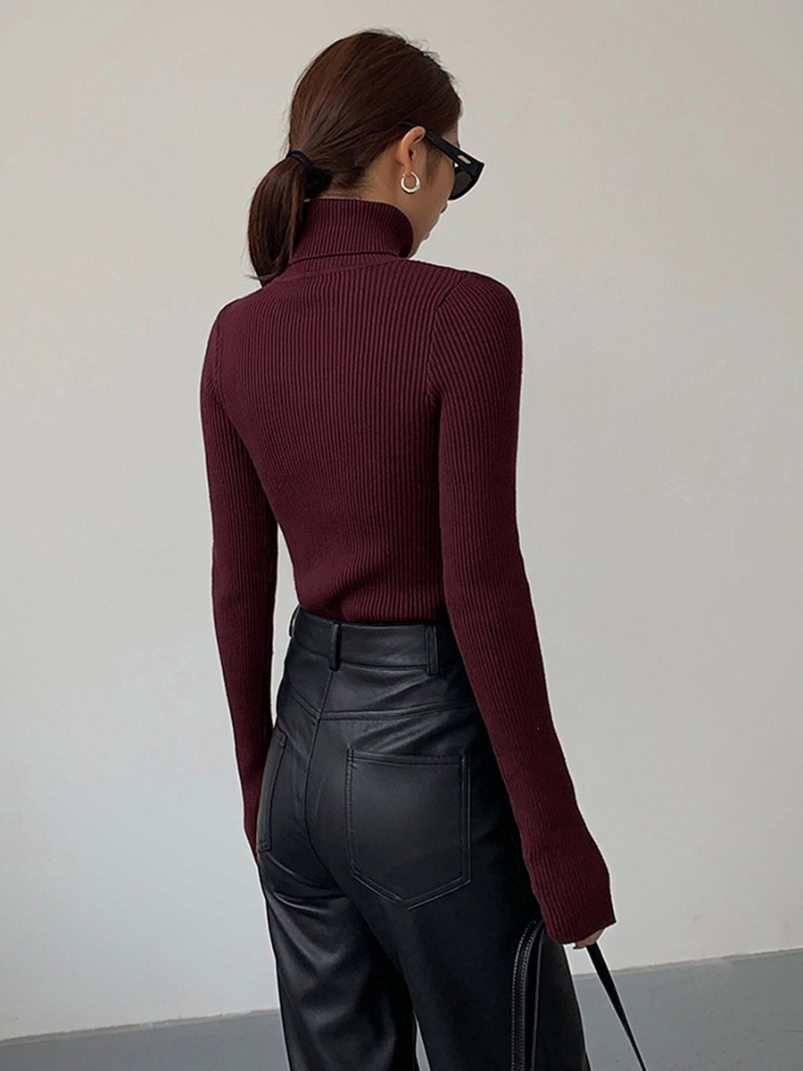 Women's sleek ribbed turtleneck sweater in a minimalist design, ideal for sophisticated winter fashion.