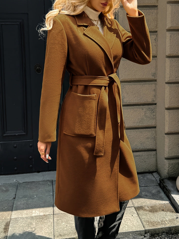Back view of a women's elegant belted trench coat. Tailored silhouette for a classic formal look.