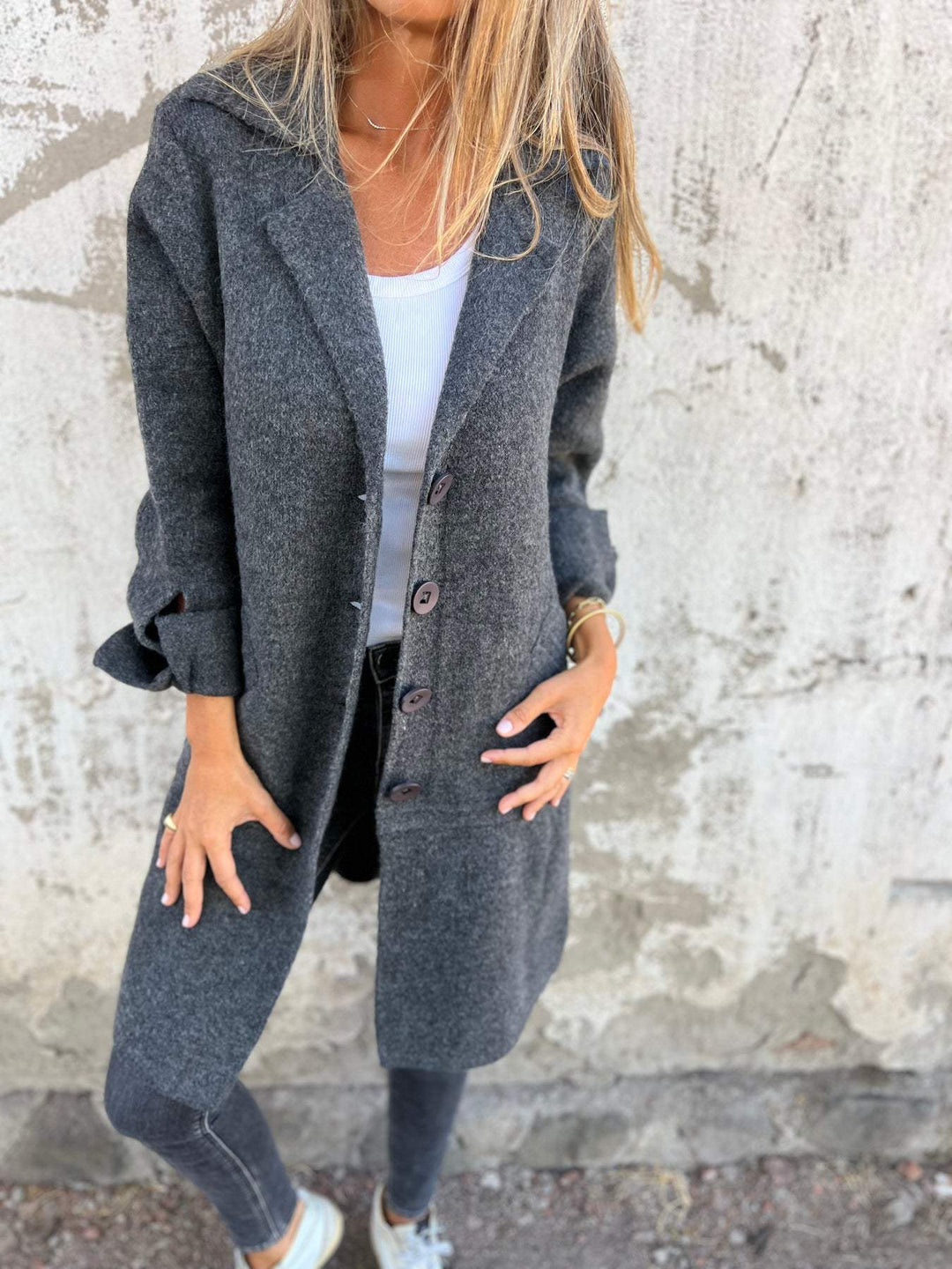 Woman wearing a chic long button coat. Versatile women's autumn outerwear, ideal for elegant fall fashion.