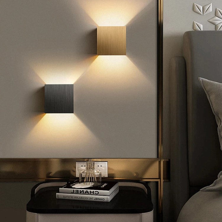 Modern LED wall sconce with up/down accent lighting. Sleek aluminum cube design for indoor home decor.