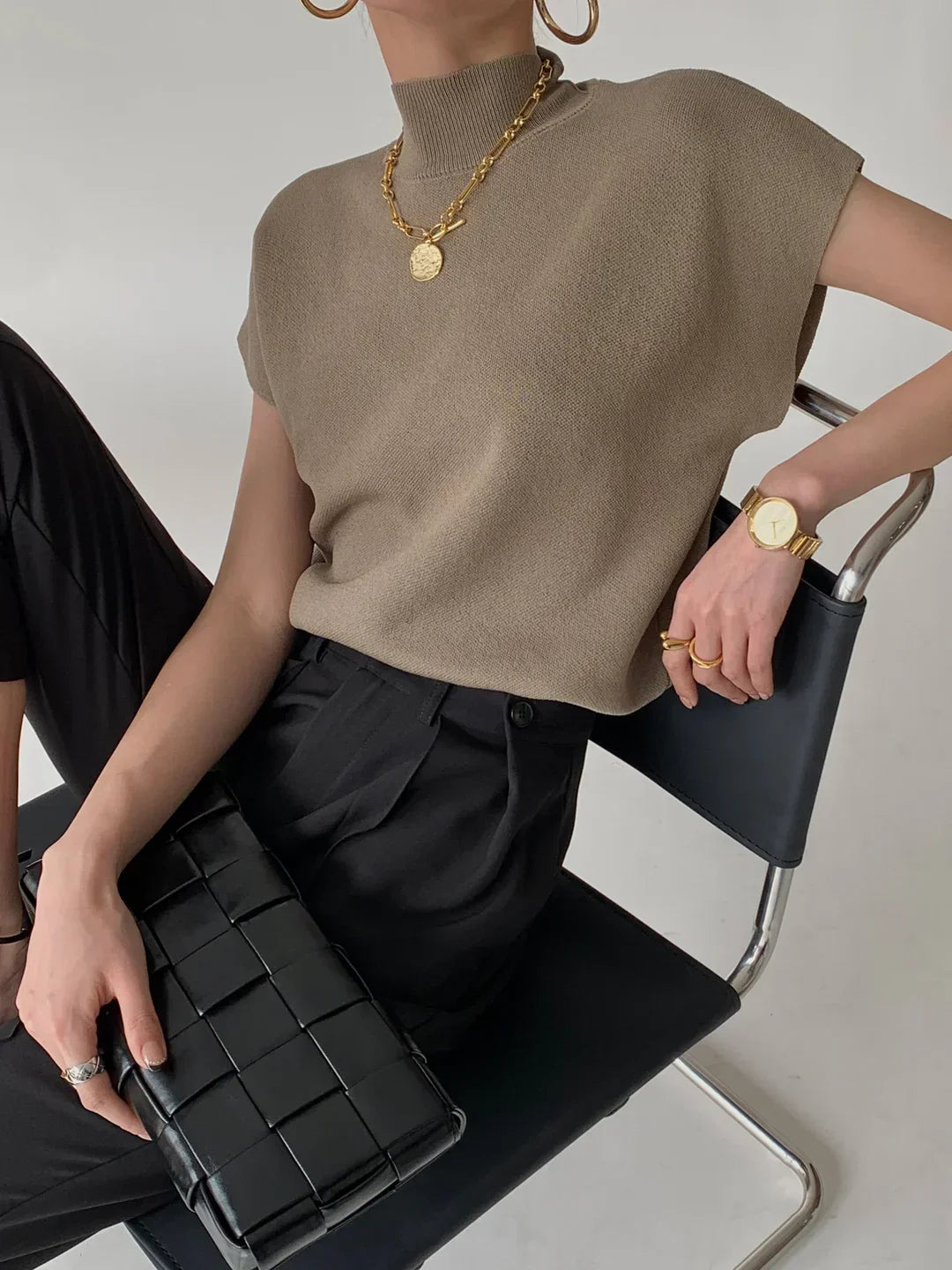 Women's smart casual top: Mock neck, sleeveless, and stylishly padded shoulders for a polished look.