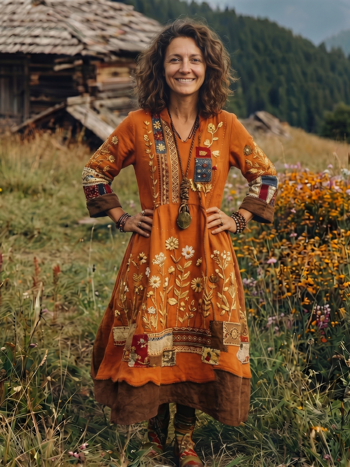 Detailed long sleeve embroidered women's midi dress, showing flowy fabric and elegant paneling. Relaxed fit style.