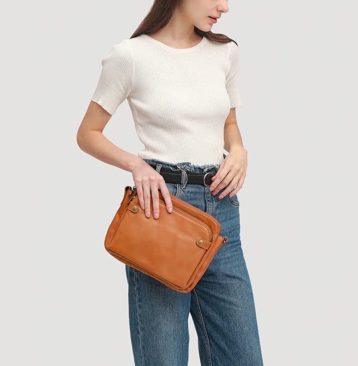 Secure women's leather crossbody bag with multiple compartments, ideal for travel & daily use.