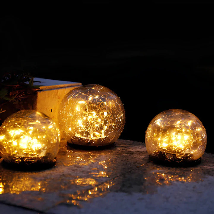 Stunning crackled glass solar orb, warm white LED light for enchanting garden decor.