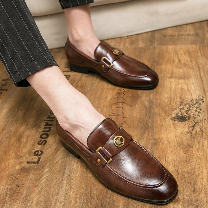 Men's fashion: stylish black slip-on loafers with a distinctive metal buckle, great for business casual outfits.