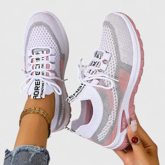 Pink women's comfort trainers with lace-up design, featuring breathable material & cushioned support.