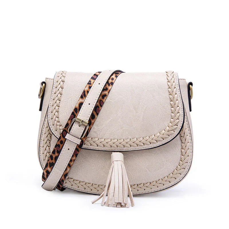 Convertible women's faux leather shoulder to crossbody bag with a fashionable tassel.