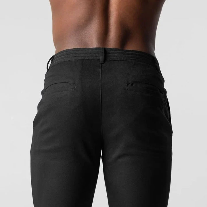 Man sitting, wearing navy versatile chino pants, demonstrating comfort & flexibility.
