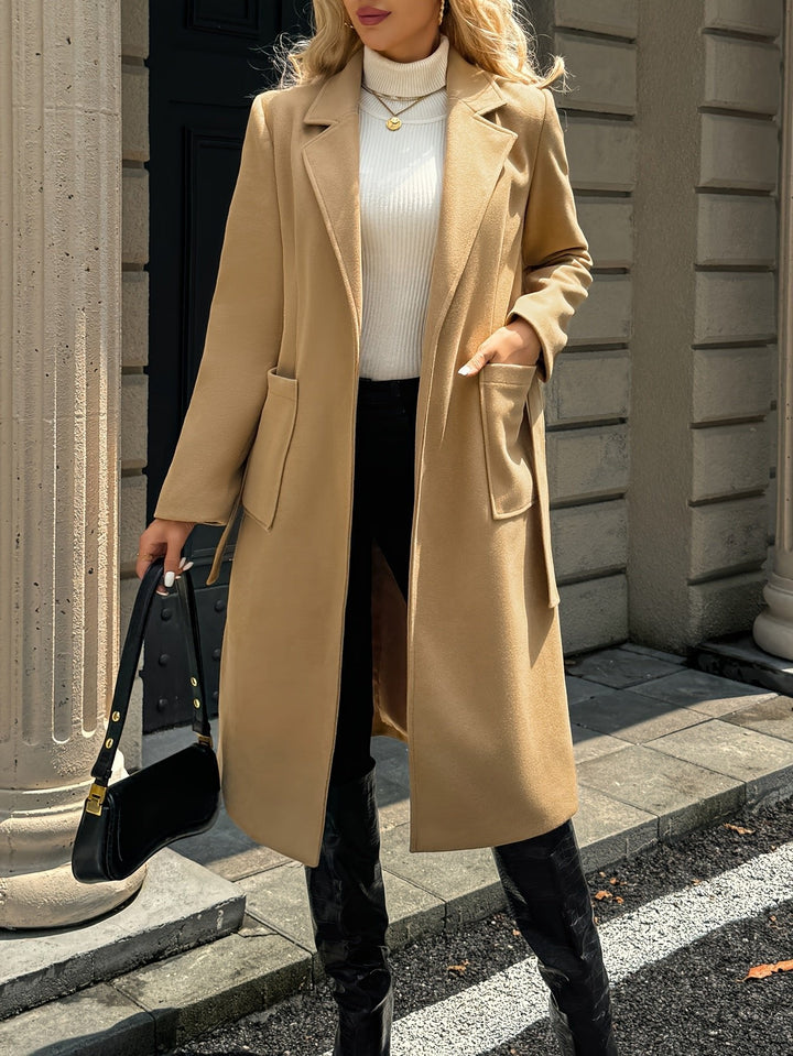Woman confidently wearing a sophisticated belted trench coat. Versatile for office or elegant outings.