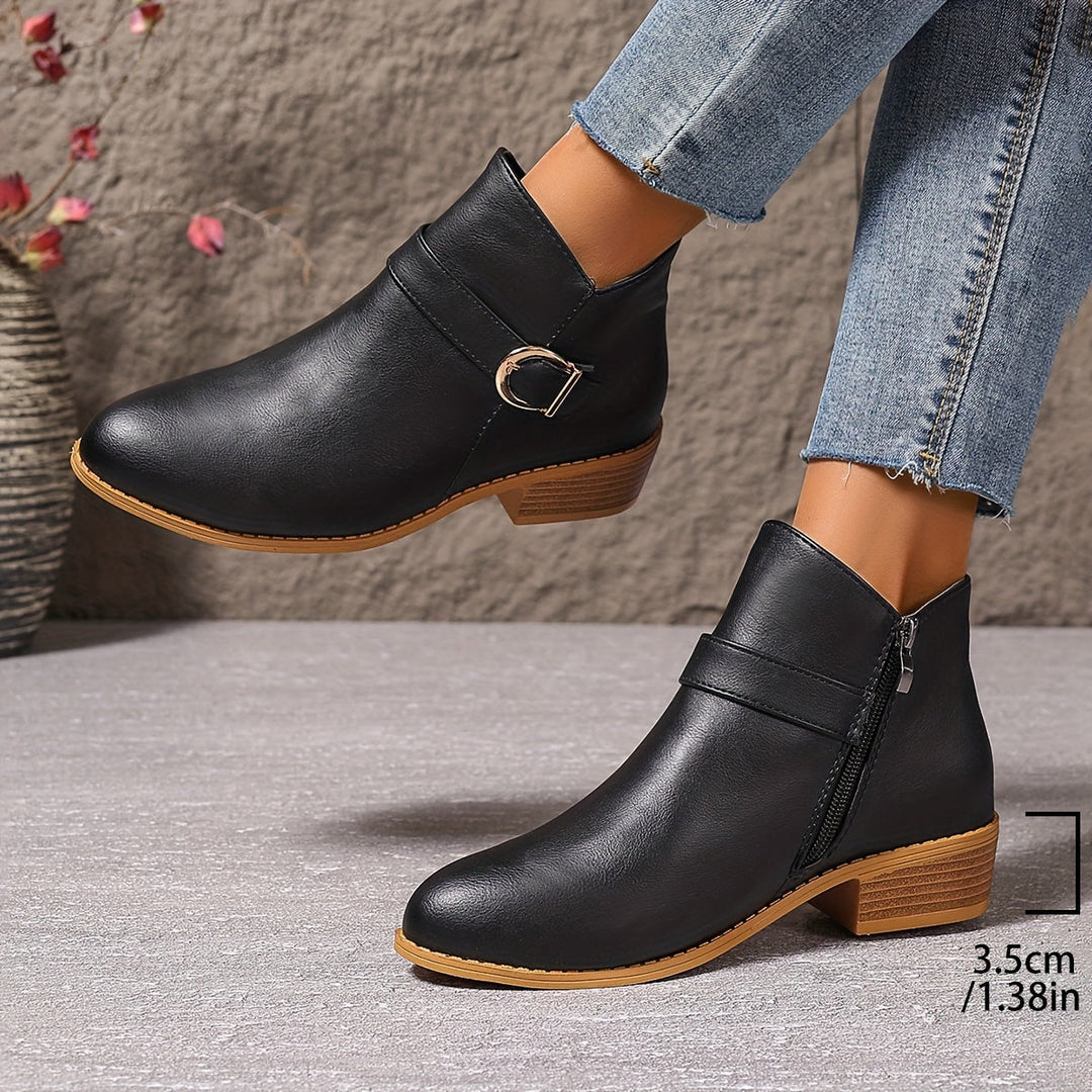 Black women's Chelsea ankle boots with side zip, modern buckle accent, and comfortable low block heel.