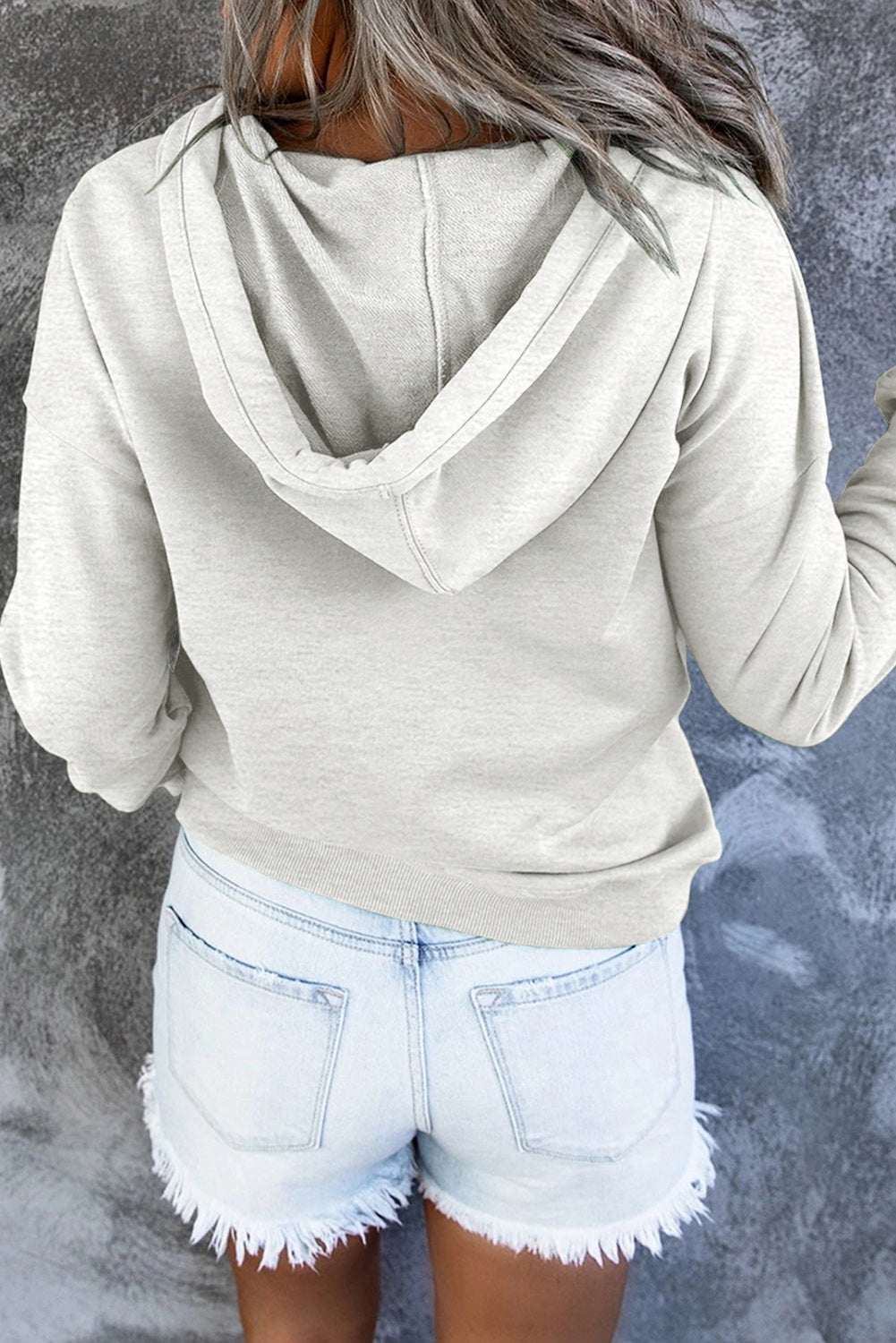 Woman enjoying outdoors in a cozy hooded sweater. Everyday casual comfort & style.
