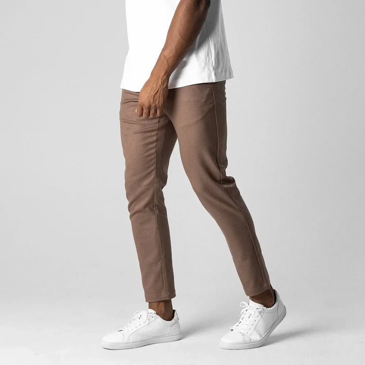 Man posing in grey versatile chinos, highlighting their modern fit and style.