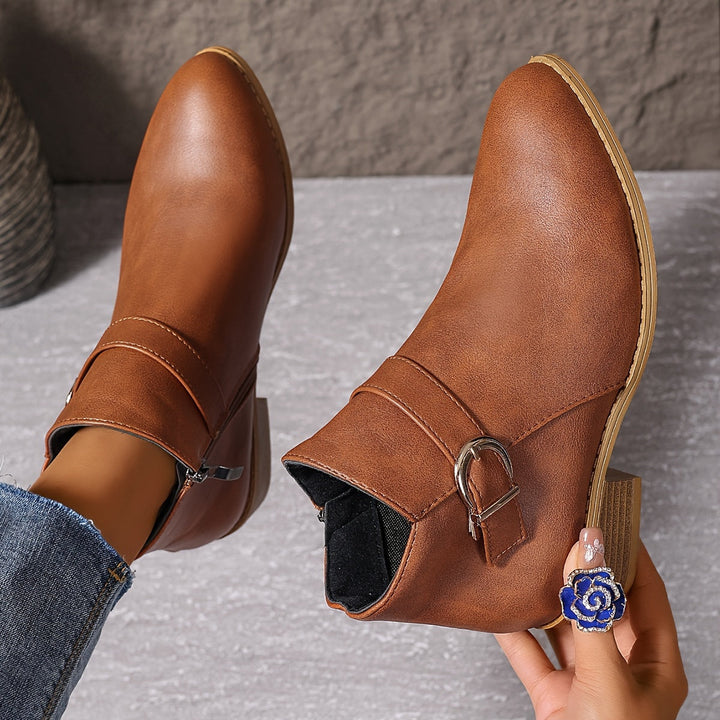 Comfortable brown Chelsea ankle boots for women with a contemporary buckle, low block heel, and side zip.