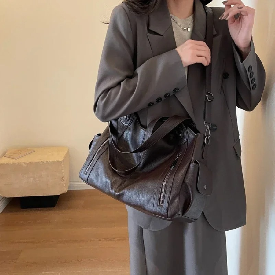 Organized women's faux leather duffle bag with shoulder strap, ideal for travel, work, or daily essentials.